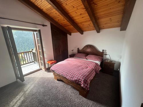 瓦托内切Chalet的一间卧室设有一张床和一个大窗户