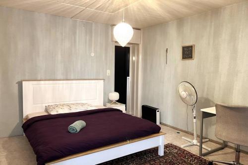 迪本多夫Cosy 4.5 rooms apartment @ LS 16 Dübendorf的一间卧室配有一张床、一张桌子和风扇