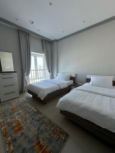 马斯喀特Kama Place的一间大卧室,配有两张床和电视