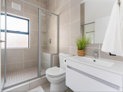 巴利托Ballito Village Luxury Apartments by DropInn的浴室配有卫生间、盥洗盆和淋浴。
