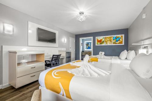 坦帕Quality Inn and Conference Center Tampa-Brandon的酒店客房设有一张大床和一台电视机。