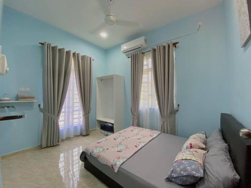 Kampong Gong BalaiNSJay Guest House的一间蓝色卧室,配有床和2个窗户