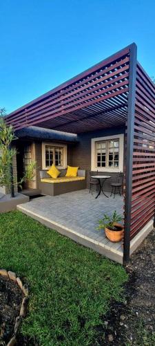 OranjevilleWaterfront Cottage Stand 122的度假屋设有带桌子和黄色枕头的庭院。