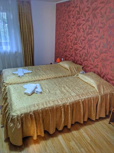 科马尔尼克Vila Drumetului的一间卧室设有两张床和红色的墙壁