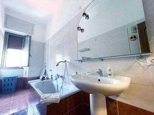 米兰Hostel Corner 32的浴室配有盥洗盆、镜子和浴缸