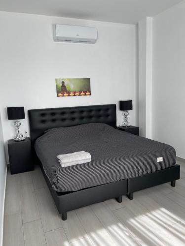 帕拉马里博Boa vista appartementen的一间位于客房内的带黑色床的卧室