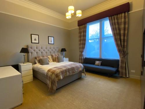 爱丁堡WM公寓酒店的一间卧室配有一张床、一张沙发和一个窗口