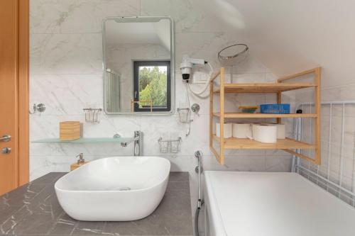 普雷德沃尔Apartments Nikolaj的一间带大型白色浴缸和镜子的浴室
