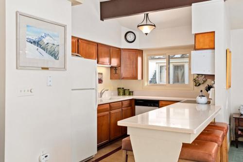 阿斯潘118 E. Bleeker Street Home, Large, Two-Level Home/Duplex with Private Deck & On-Site Parking的厨房配有白色冰箱和木制橱柜。