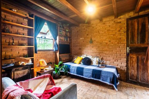 贡萨尔维斯Sitio Tahiupara的一间卧室设有一张床和砖墙