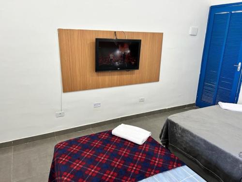 圣保罗Studio mobiliado na Vila Guilherme - São Paulo/SP的客房设有两张床和一台墙上的电视