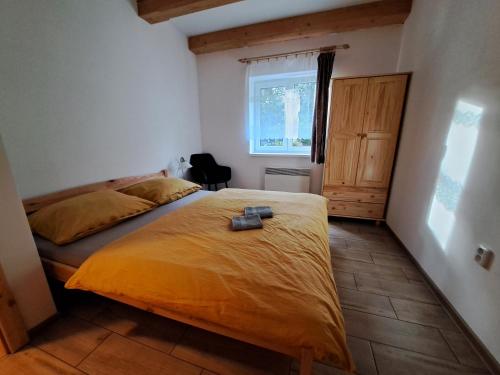 多尔尼莫拉瓦Chalupa Petra的一间卧室配有一张带黄色床罩的床和窗户