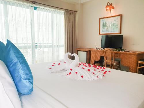 芽庄GREEN ANT NHA TRANG的酒店客房,配有一张红色的白色床