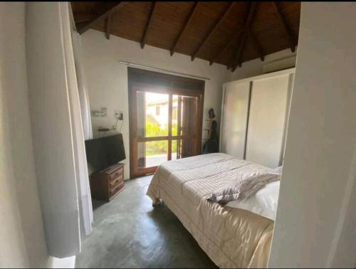 加罗帕巴Aconchegante e charmosa casa的一间卧室设有一张床和一个大窗户