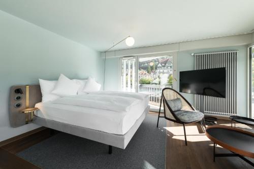 图恩Hotel Aare Thun的卧室配有一张白色大床和电视。