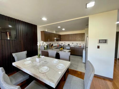 昆卡Maravilloso departamento con moto electricá的厨房以及带桌椅的用餐室。