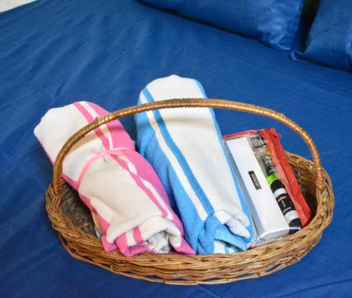 斋浦尔Housetel的床上的带毛巾和其他物品的篮子