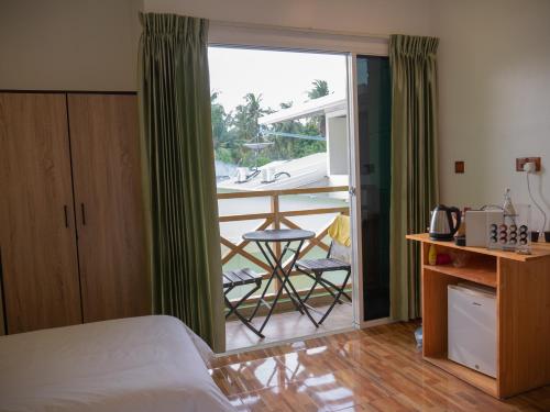 OmadhooTurtle Maldives - Your Gateway to the Beach & Marine Adventures Await!的一间卧室设有一张床,享有阳台的景色