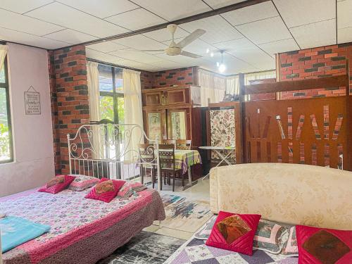 峇六拜Dusun Indah Cottage 2的一间设有床铺的房间和一间用餐室