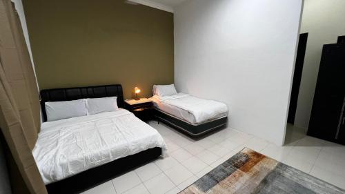 珍南海滩Rerama Room Stay Langkawi的客房设有两张床和一张带台灯的桌子。