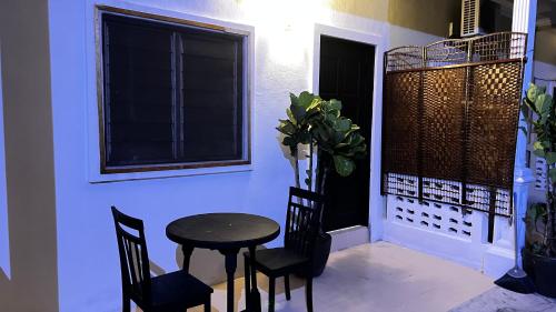 珍南海滩Rerama Room Stay Langkawi的窗户客房内的小桌子和椅子
