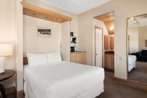 阿斯潘Independence Square 300, Nice Hotel Room with Great Views, Location & Rooftop Hot Tub!的卧室配有白色的床和镜子