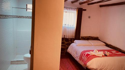 奥兰太坦波Mirador inka的一间卧室配有一张床,上面有两个娃娃