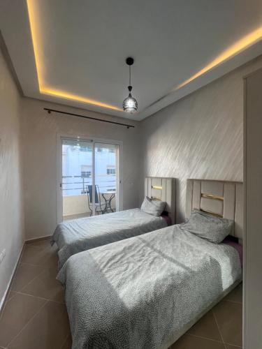 盖尼特拉Luxury Center Town Apartment的一间卧室配有两张床和一张桌子及椅子
