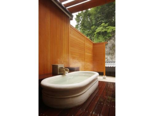 日光Kinugawa Onsen Yusuikiko Hotel Otaki - Vacation STAY 68843v的带浴缸的浴室,设有木墙
