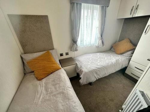 Kinmel Bay6 berth luxury caravan, Lyons Winkups Holiday Park的一间小卧室,配有两张床和窗户