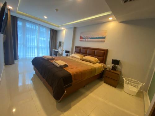 芭堤雅市中心Large Deluxe Condo Grand Avenue Central Pattaya的一间卧室设有一张床和一个大窗户