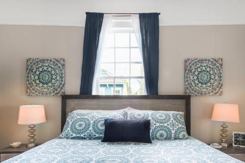 新奥尔良Shotgun Craftman House with Private Patio的一间卧室配有一张带两盏灯的床和一扇窗户。