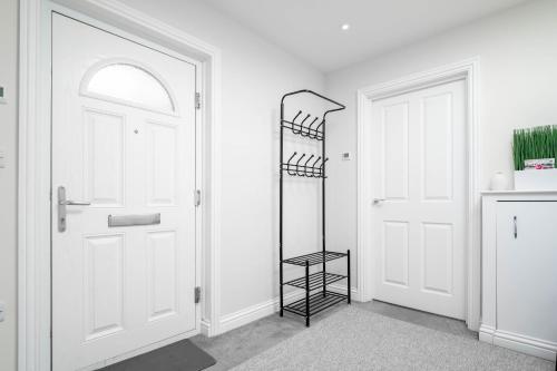 红山Garland Penthouse - Large 2 bed 2 bath self contained flat的白色走廊,有白色门和黑色架子