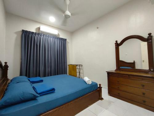 马六甲Homestay Melaka Baitul Saadah的一间卧室配有一张床、梳妆台和镜子