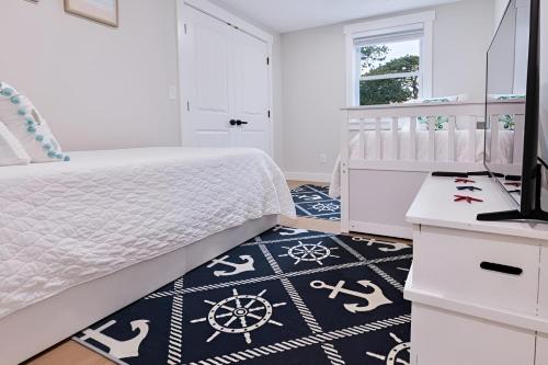 巴恩斯特布尔Renovated & Sophisticated Home Near Beach & Shops!的卧室配有白色的床和黑白地毯。