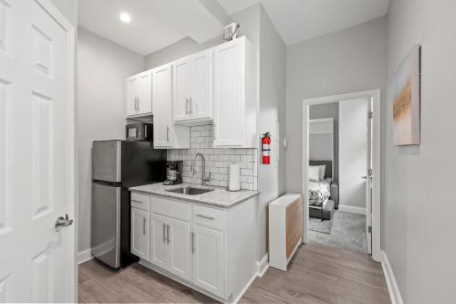 大洋城Lovely Renovated 1Bdrm 1Bath Getaway的厨房配有白色橱柜和黑色冰箱。
