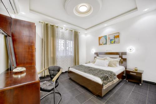 杜阿拉Cosy Home的酒店客房配有一张床、一张桌子和一把椅子。