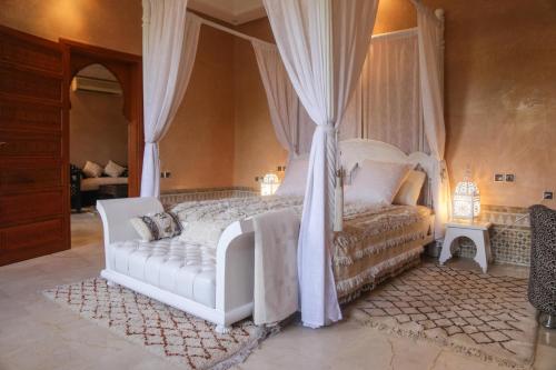 马拉喀什Villa Taj Sofia & Spa的一间卧室配有一张带天蓬的白色床