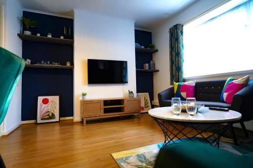 伦敦Enfield North London 3BR Apartment的客厅配有桌子和电视