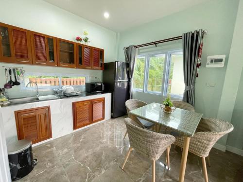 卡农อิงแลนด์เฮ้าส์แอนด์พูล England8House&Pool的厨房配有桌椅和冰箱。