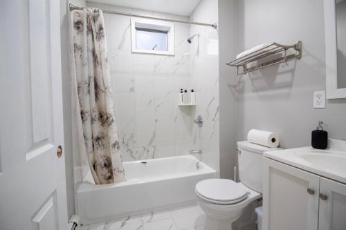 波士顿2 bedroom condo close to Boston and Cambridge with free parkings的白色的浴室设有浴缸、卫生间和水槽。