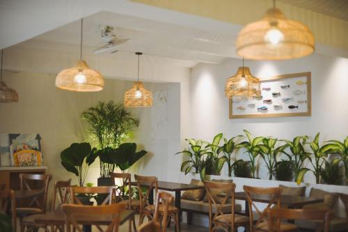 龙川市Phuong Nam Hotel An Giang的用餐室配有桌椅和盆栽植物
