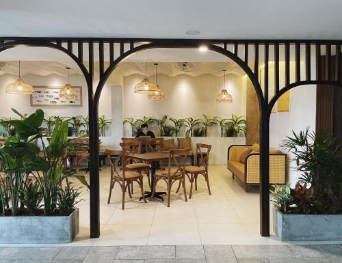 龙川市Phuong Nam Hotel An Giang的一间设有桌椅和植物的餐厅