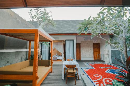 金巴兰Villa Bulan Bali的天井配有沙发、桌子和地毯。