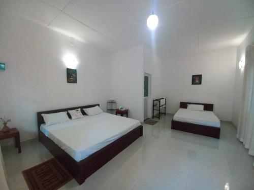 阿努拉德普勒S & D Resort的一间白色客房内带两张床的卧室