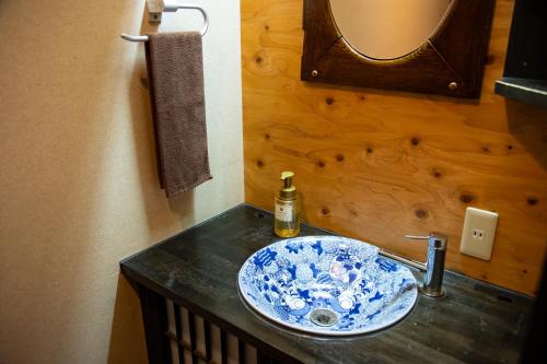 别府Yasuraginoyado Yufu的浴室水槽设有蓝色和白色的碗