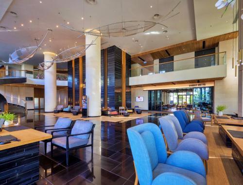 归仁Anya Premier Hotel Quy Nhon的大堂设有蓝色的椅子和桌子。