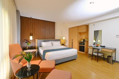马尼拉Ardenhills Suites的配有一张床和一张书桌的酒店客房