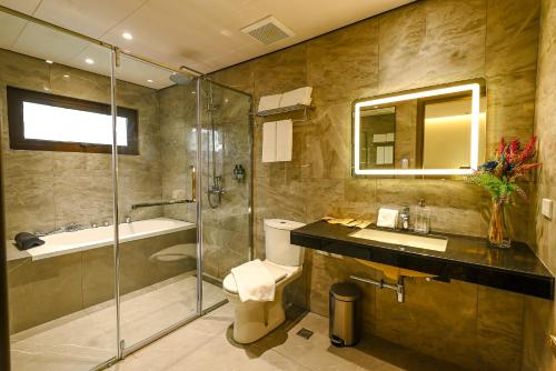 马尼拉Ardenhills Suites的带淋浴、卫生间和盥洗盆的浴室
