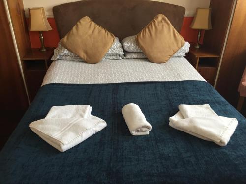 滨海绍森德Welbeck Hotel - Close to Beach, Train Station & Southend Airport的一张带毛巾和枕头的床